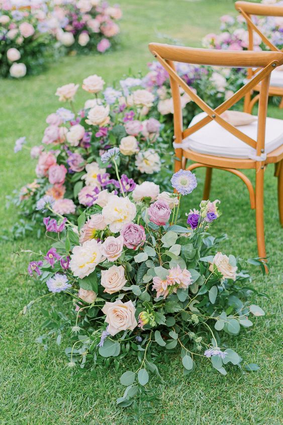 an exquisite spring wedding aisle with lush greenery, lilac, blush and peachy blooms is a very chic and beautiful idea
