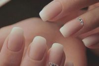 an ombre French manicure with shiny rhinestones on ring fingers is a frehs take on the traditional bridal choice