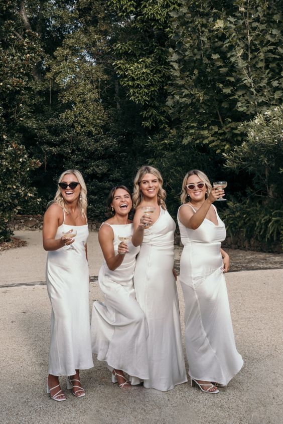 chic mismatching white satin maxi bridesmaid dresses with various necklines are amazing for a modern wedding with a chic feel