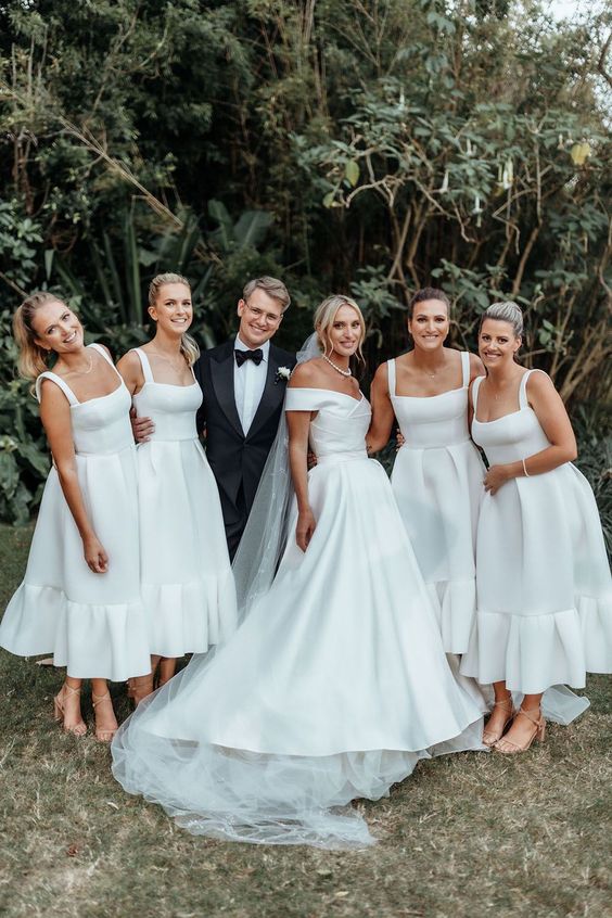 classic white midi A-line bridesmaid dresses with straps and square necklines plus nude shoes for a stylish formal wedding