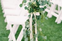 lovely and delicate spring wedding aisle decor with greenery and white ribbon bows is amazing for a fresh look