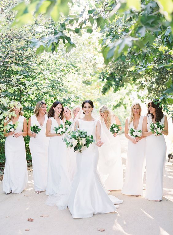 matching white semi-fitting maxi bridesmaid dresses with plunging necklines and no sleeves are amazing for neutral wedding