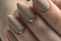 matte off-white bridal nails with a touch of gold glitter on two of them are very chic and stylish