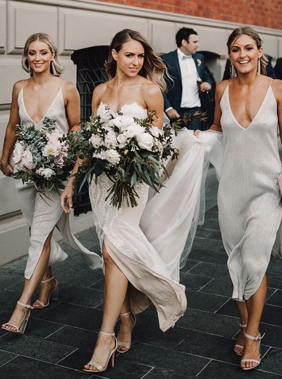 minimalist yet sparkly white midi bridesmaid dresses with deep necklines and side slits, nude heels for a minimalist wedding