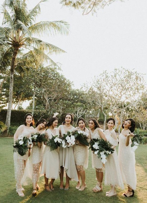 mismatching white midi bridesmaid dresses with polka dots and various sandals for a modern tropical wedding