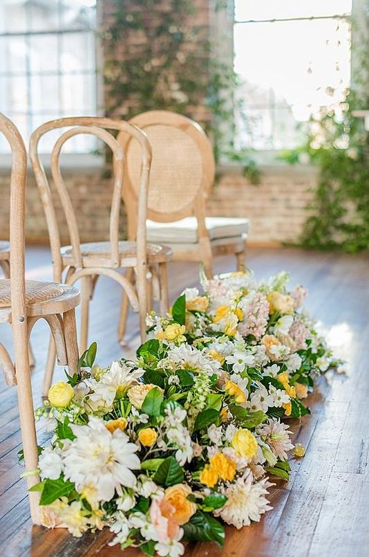 refined bright spring wedding aisle decor with white, yellow and blush blooms and greenery will give a slight vintage feel to the space