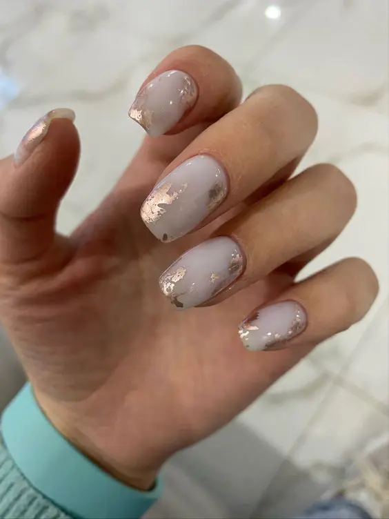white wedding nails with gold brushstrokes here and there is a very artful manicure that will add interest to any bridal look