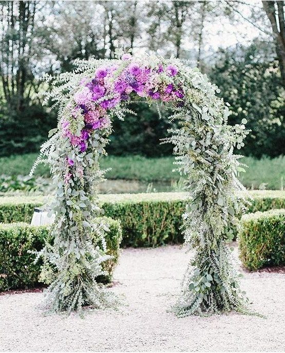 a beautiful wedding arch covered with eucalyptus and purple blooms is a very lovely and chic idea to rock in spring