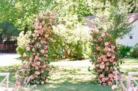 03 a beautiful wedding ceremony space done with an altar with lush greenery and pink blooms, with matching blooms lining up the aisle