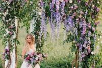 08 a very natural wedding arch with much greenery, purple and light pink blooms and some neutral fabric is wow