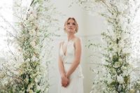 13 an ethereal wedding arch with greenery and white blooms and blooming branches all around is amazing