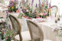 16 bright freeform florals placed on the reception tables and on the floor create a feeling of an indoor garden
