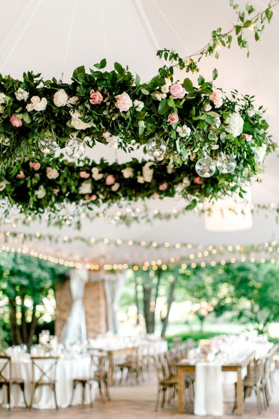 a refined and chic wedding chandelier of greenery, white and pink blooms and tiny candles in bubbles is amazing