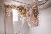 18 a jaw-dropping overhead floral installation that includes neutral and blush dried blooms hanging over the table