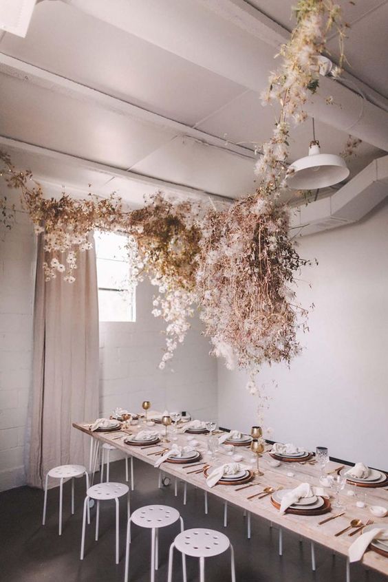 a jaw-dropping overhead floral installation that includes neutral and blush dried blooms hanging over the table