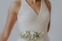 37 an elegant draped bridesmaid dress accessorized with a delicate neutral flower belt with greenery