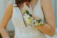 39 a catchy tan and white lace fitting wedding dress with a covered plunging neckline and a long neutral flower bracelet wrapping the arm