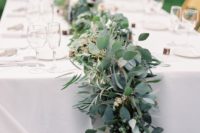 a beautiful and lush greenery garland refreshes the neutral tablescape and gives it a festive look