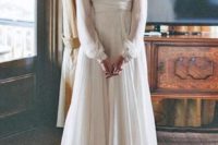 a beautiful and simple empire waist wedding dress with a draped bodice, a plunging neckline, long sleeves and a pleated skirt