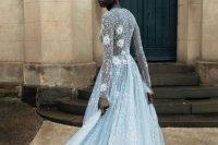 a blue A-line wedding dress with florla appliques and embellishments, with long sleeves and a train is a dreamy idea