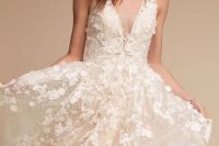 a blush A-line wedding dress with white floral appliques, a plunging neckline and no sleeves is a dream y and pretty solution