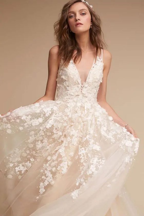 a blush A-line wedding dress with white floral appliques, a plunging neckline and no sleeves is a dream y and pretty solution