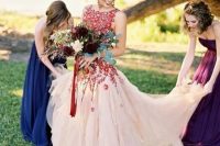 a blush scoop neckline wedding dress with bold red floral appliques over the whole bodice and a train is dramatic