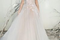 a blush tulle wedding ballgown with an illusion bodice and white floral appliques on the shoulders and bodice