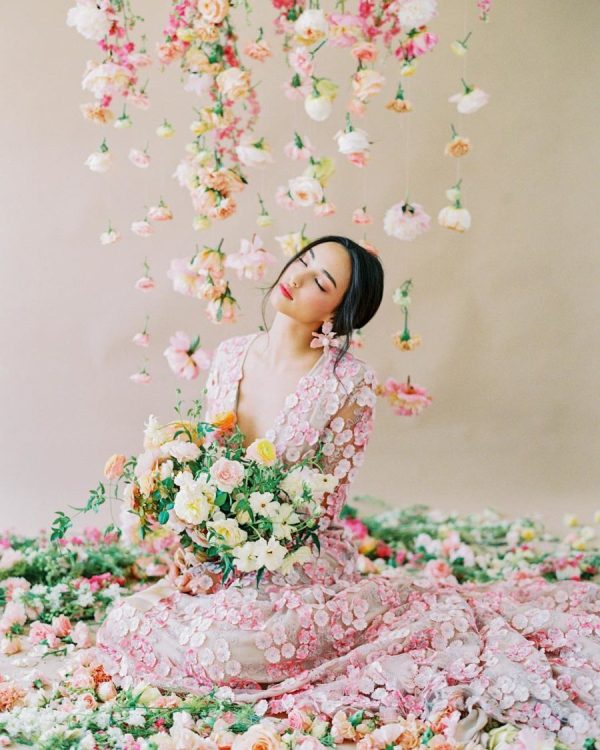 a blush wedding dress completely covered with pink floral appliques and with matching earrings for a spring bride