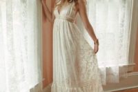 a boho lace A-line wedding dress with a deep neckline, no sleeves and a floral crown for a hippie bride