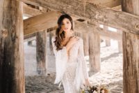 a boho lace mermaid wedding gown with a plunging neckline, bell sleeves and loose waves