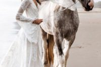 a boho lace wrap wedding dress with bell sleeves and a train plus statement earrings