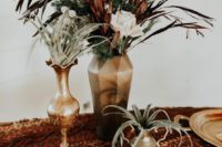 a boho wedding centerpiece with gold vases and pots, air plants, greenery, blush and rust-colored blooms