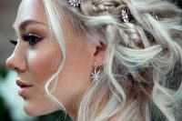 a braided messy updo accented with rhinestone star hair pins and matching earrings for a celestial bride