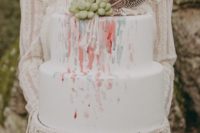 a bright watercolor wedding cake with succulents and feathers plus real macrame for plate decorating