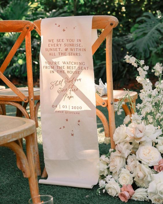 a chair with blooms next to it and a banner saying about love to the person who is missing
