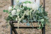a chair with greenery and blooms and a photo of the deceased bride’s father is a cool idea to honor him at the wedding