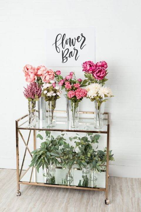 a chic and modern flower bar with pink and white blooms and greenery to make your own bouquet