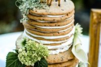 a chocolate chip cookie wedding cake with creamy filling, greenery and funny deer toppers