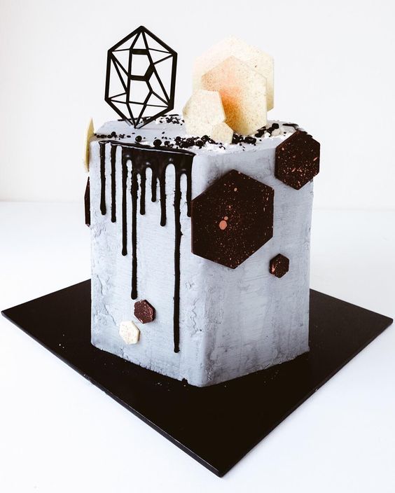 a concrete hexagon groom's cake with chocolate drip, chocolate and sugar hexagons and a monogram is a super cool and refined idea