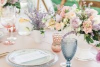 a cute pastel bridal shower tablescape with pink linens, pink, white blooms and lavender, blue and pink glasses