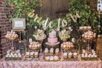 a cute pink spring bridal shower dessert bar done with greenery, calligraphy and pink blooms