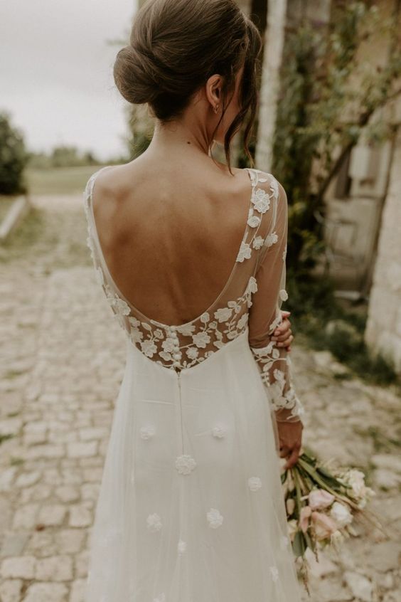 a dreamy and romantic A-line wedding dress with a cutout back, petal appliques and illusion sleeves is a beautiful and delicate solution