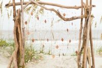a driftwood wedding arch with hanging wooden rhombs and beads is great for a coastal or beach wedding