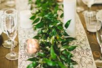a greenery table runner with a white lace one underneath looks very neat and elegant