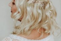 a half updo with a halo braid and waves accented with a hair vine for a boho bride