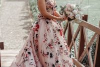 a jaw-dropping blush A-line wedding dress with colorful floral applique, a deep neckline and spaghetti straps plus a train