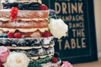 a large naked wedding cake with fresh berries and blooms and sugar powder on top looks super yummy