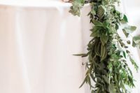 a lush eucalyptus and succulent table runner features much texture and various shades of succulents, too