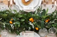 a lush greenery table runner dotted with fresh citrus is ideal for a Mediterranean or tropical wedding